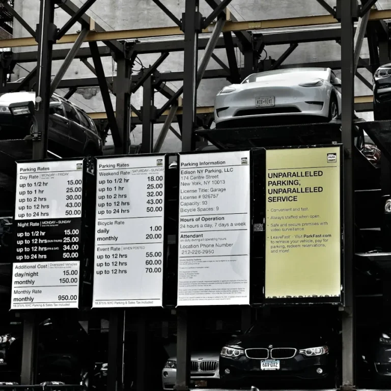 Stacked car-lift parking garage in New York City with posted hourly and monthly rate boards